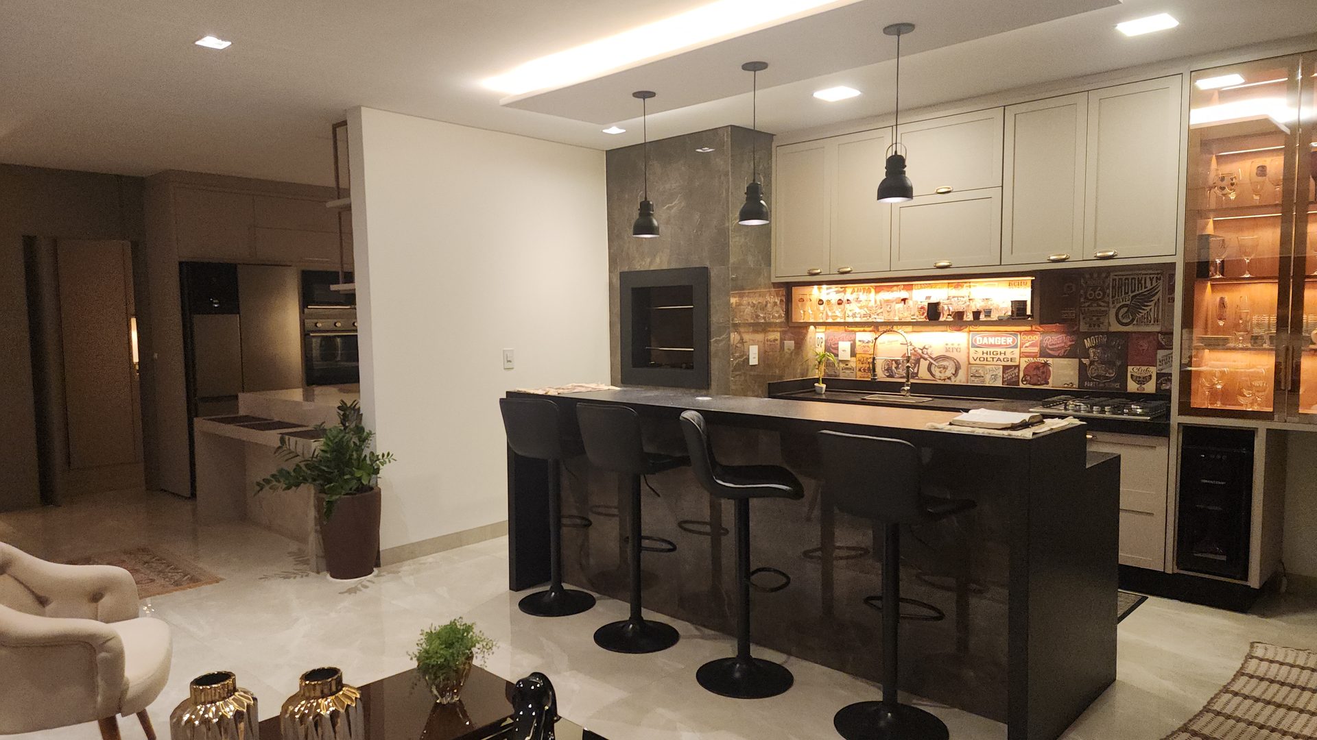 Cozinha gourmet com ilha, wine cooler e pendentes industriais no sobrado 3 suites Terras Alpha