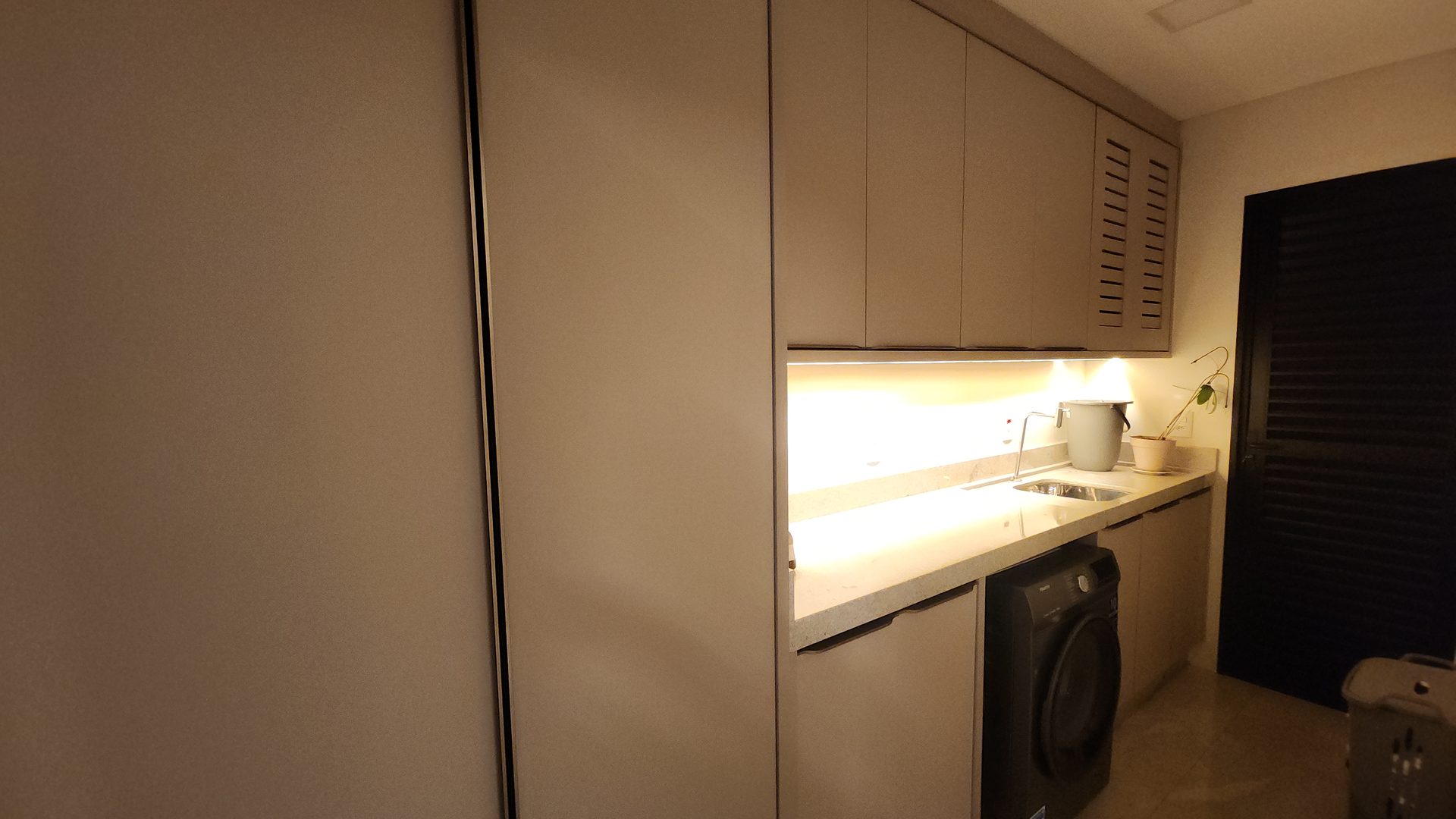 Lavanderia com armarios planejados e iluminacao LED no sobrado 3 suites Terras Alpha