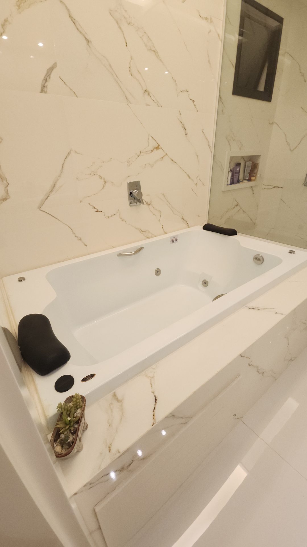 Detalhe da banheira de hidromassagem com revestimento em marmore Calacatta no sobrado Alphaville