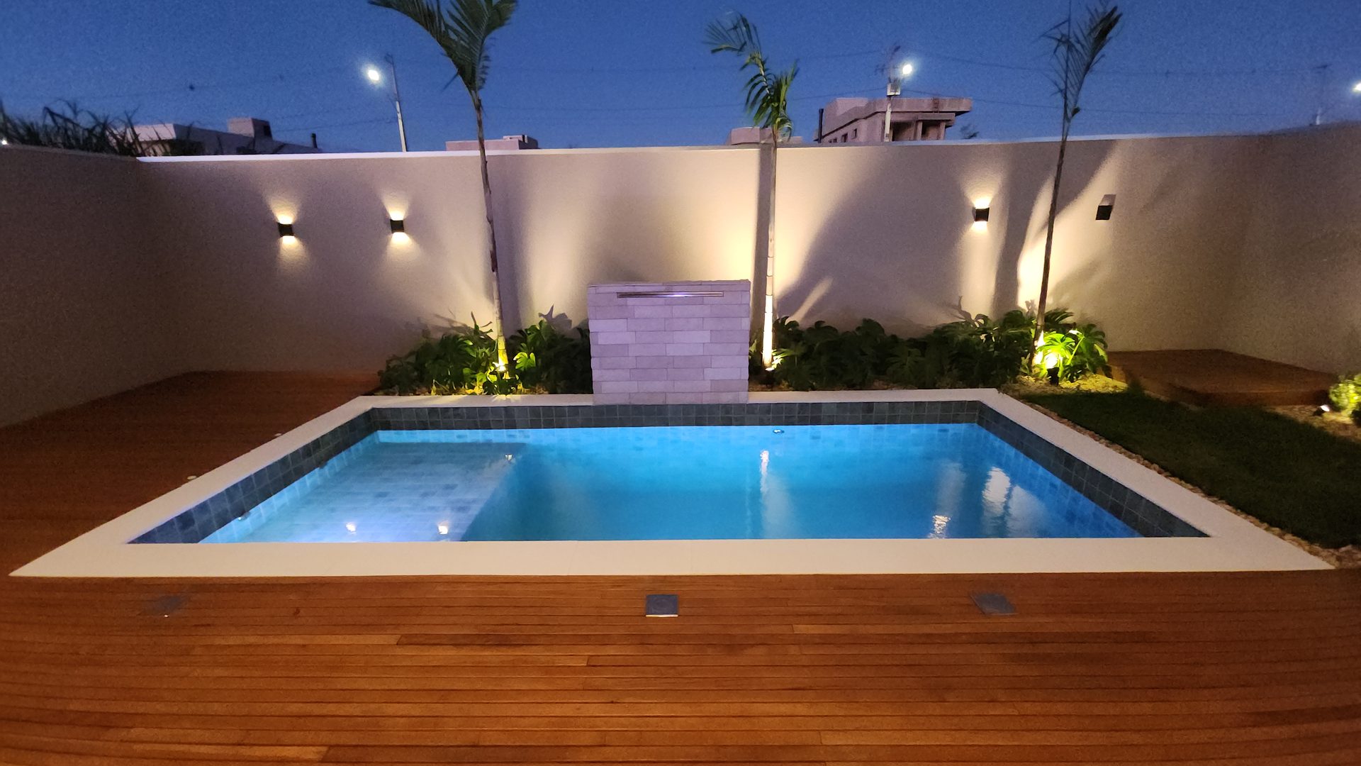 Piscina com jardim e palmeiras iluminadas no sobrado Alphaville Cascavel